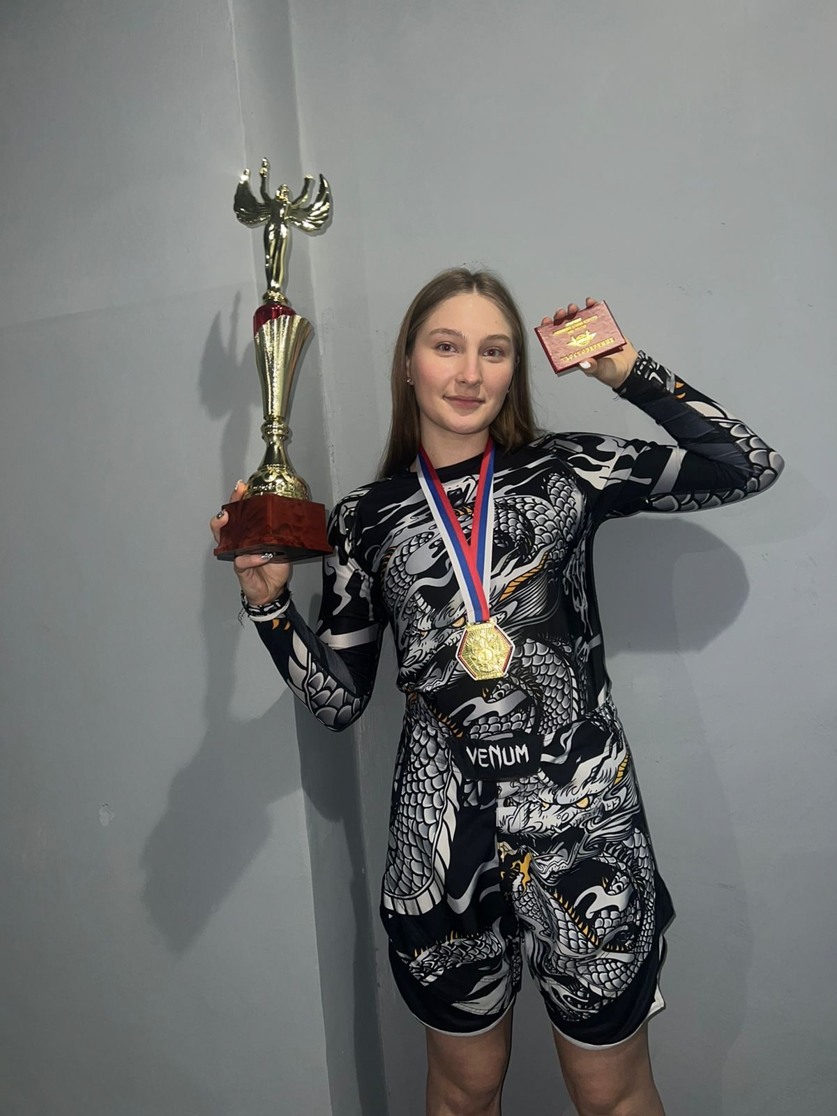 Виктория Ибрагимова с кубком, медалью и удостоверением спортсмена