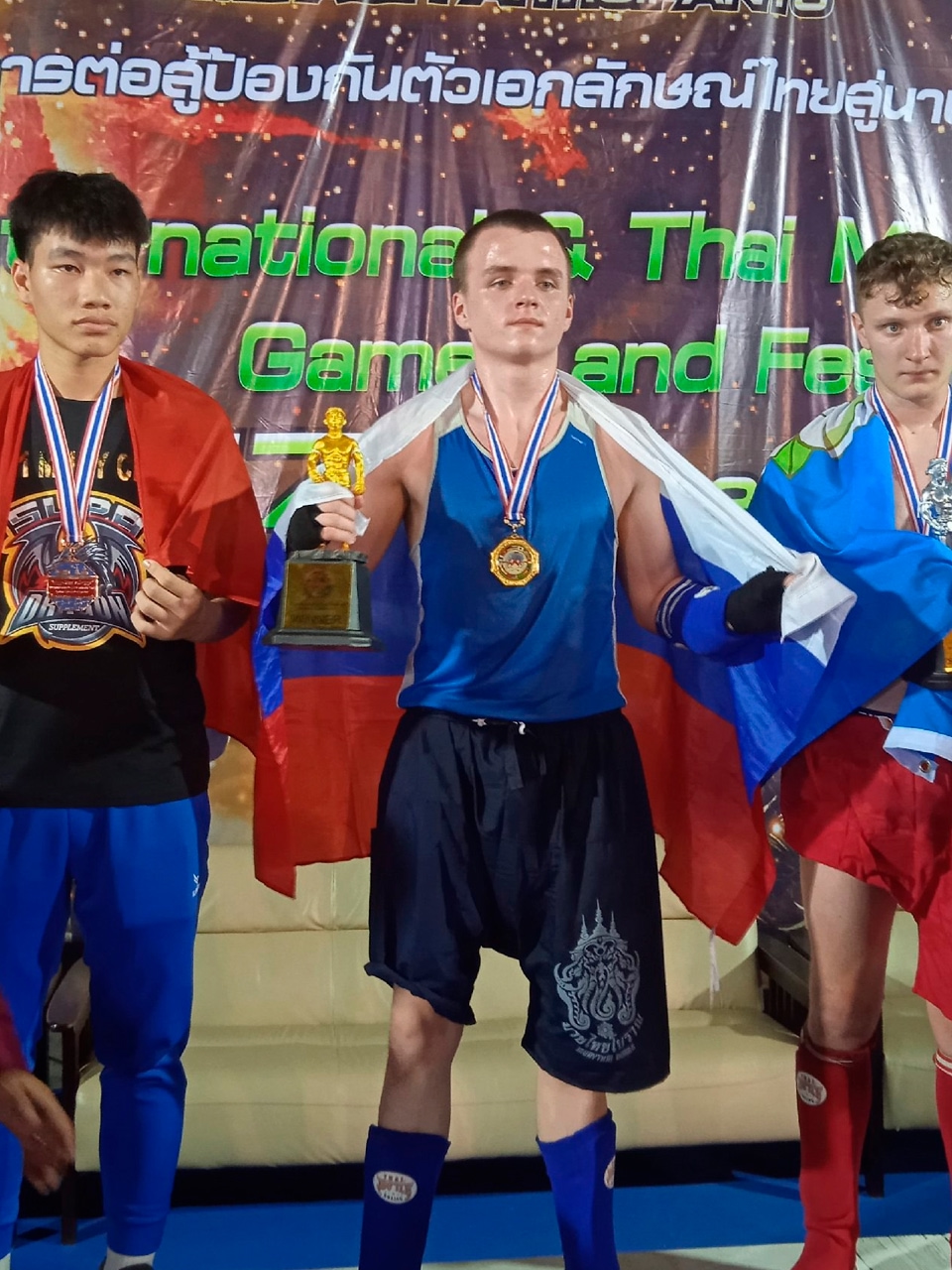 Вячеслав Шведчиков на пьедестале с чемпионским кубком и флагом России